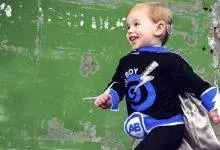 طفل يرتدي زي بطل خارق مبتسم