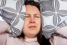 امرأة تضغط وسادة على أذنيها