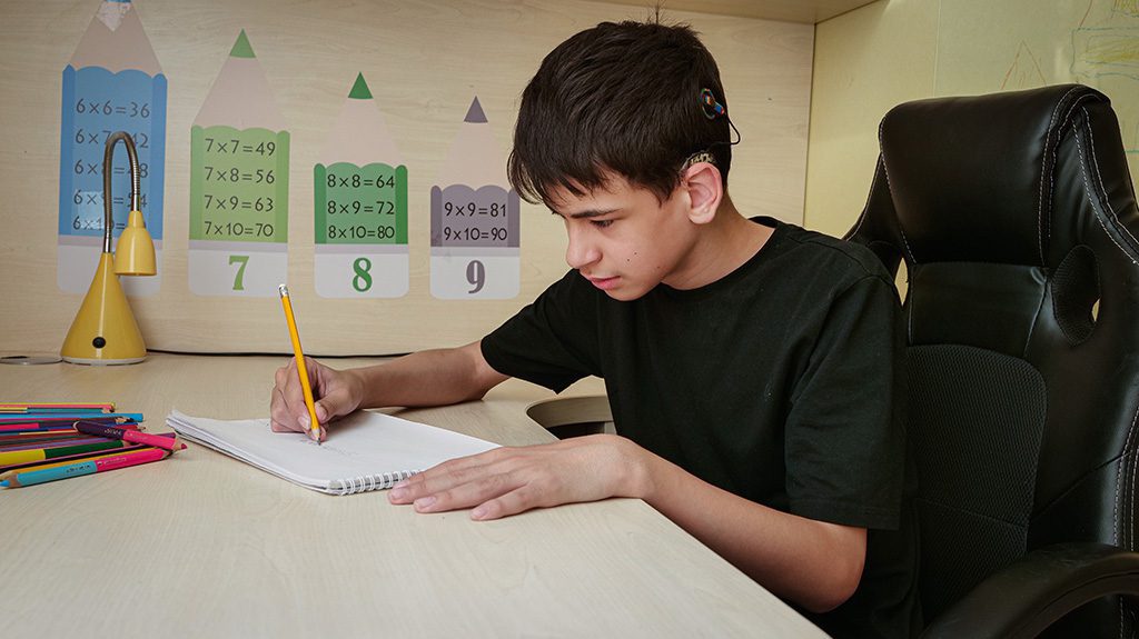 Enfant étudiant mathématiques à son bureau.