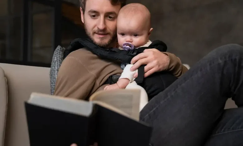 Homme lisant un livre à un bébé.