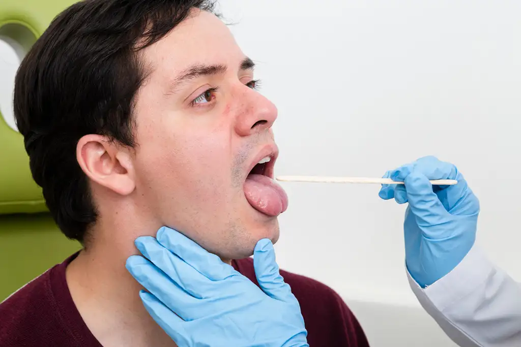 Examen médical de la gorge par un médecin.