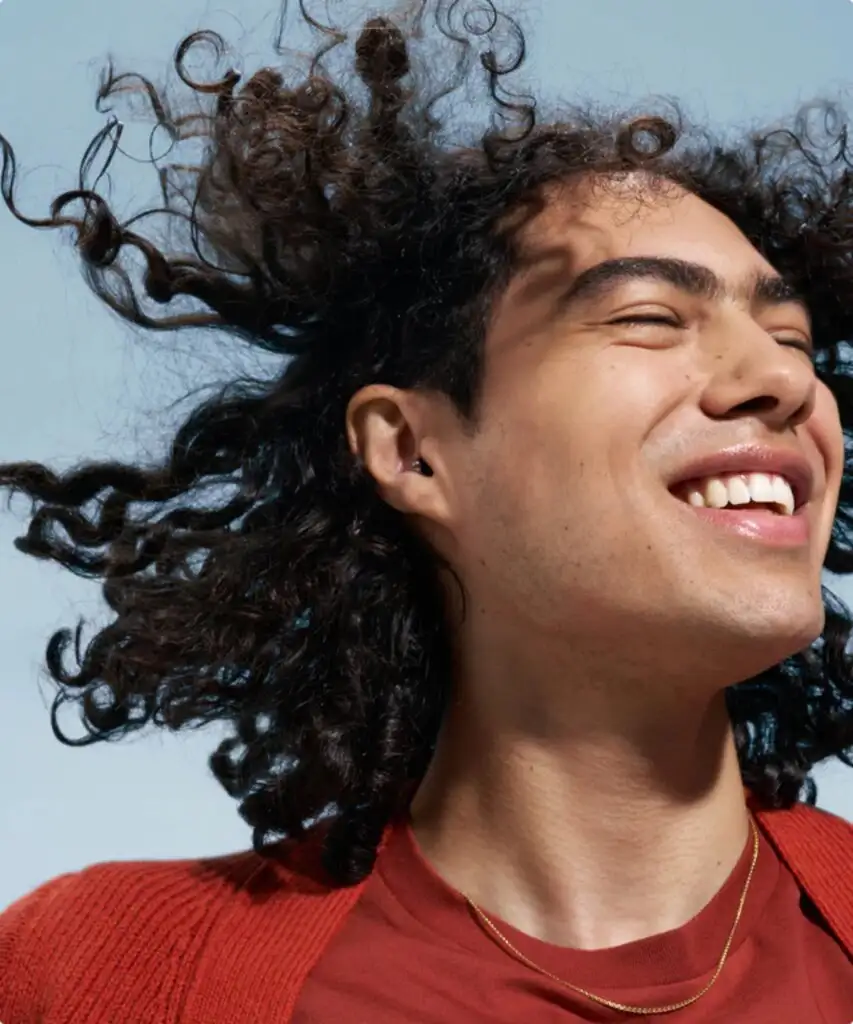 Personne souriant avec cheveux au vent